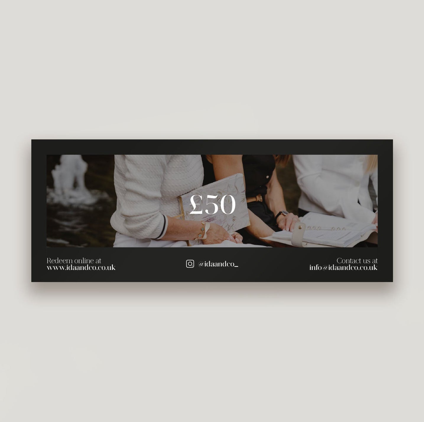 Black framed photo of a person holding money with '£50' displayed, on a light gray background.