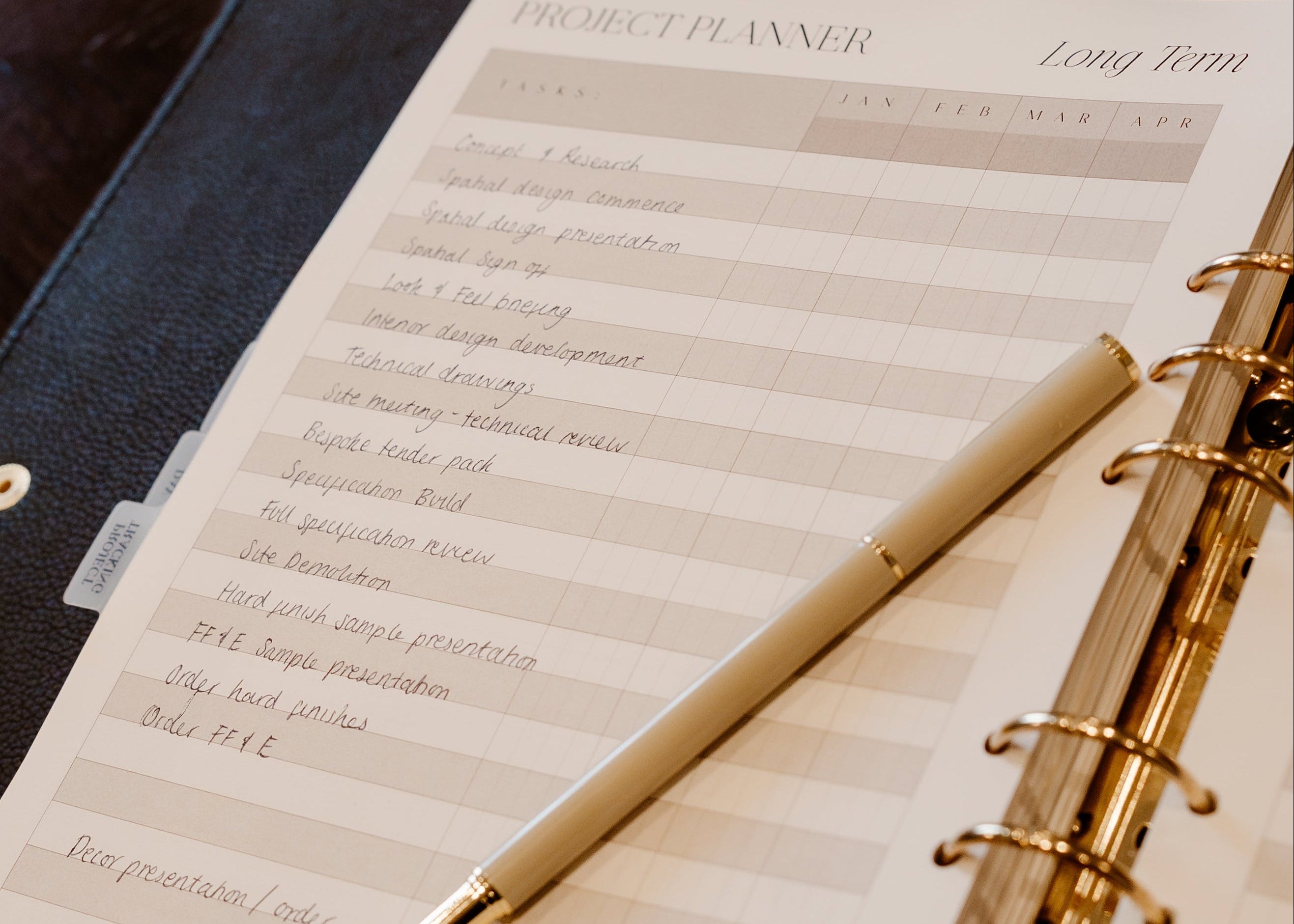 Open planner with pen on a wooden surface